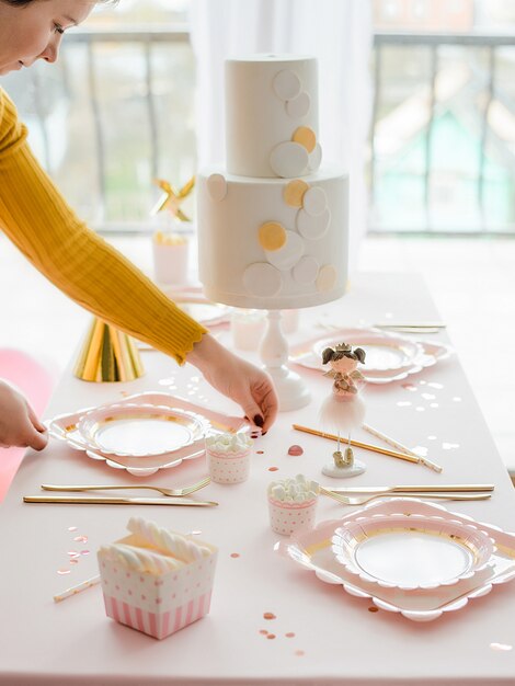 Mesa decorativa festiva para la cena de fiesta infantil con mantel rosa  textil, vasos y platos de papel de colores con pajitas de cóctel. feliz  cumpleaños decoración