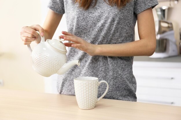 Mujer sirviendo té en la cocina