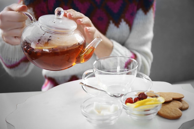 Mujer sirviendo té en la taza