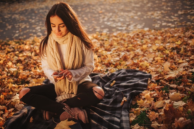 Mujer con smartphone en otoño