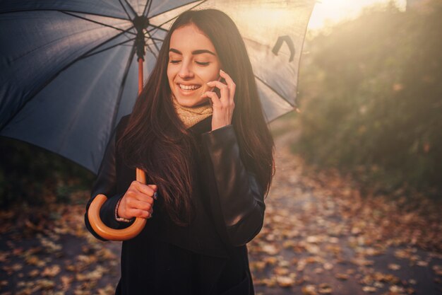 Mujer con smartphone en otoño