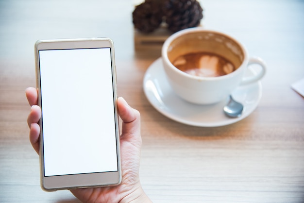 Mujer con smartphone, primer plano, taza de café en el fondo