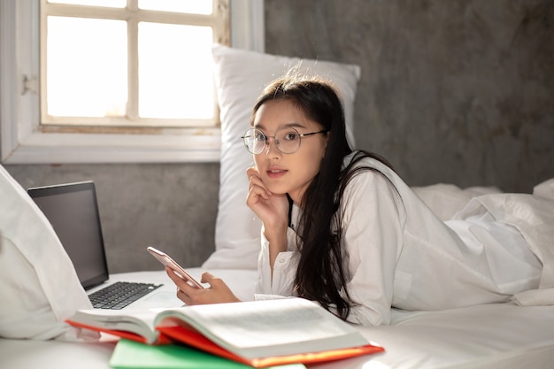 Foto mujer con smartphone en su cama