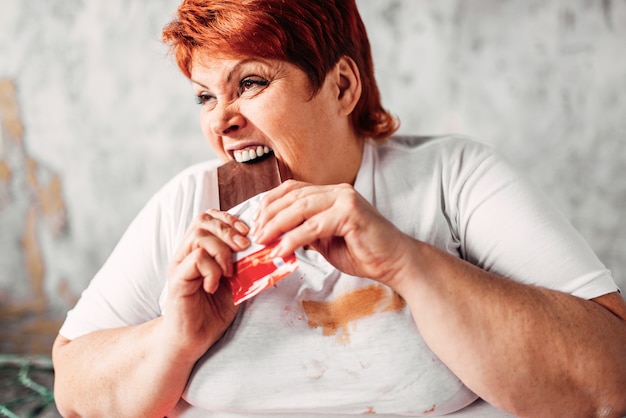 Foto mujer con sobrepeso come chocolate, obesidad