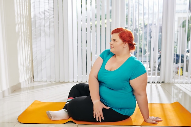 Mujer con sobrepeso descansando después del entrenamiento