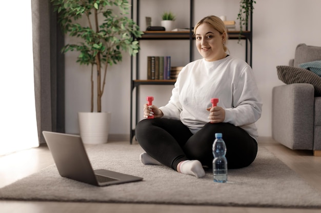 Foto mujer con sobrepeso entrenando en casa