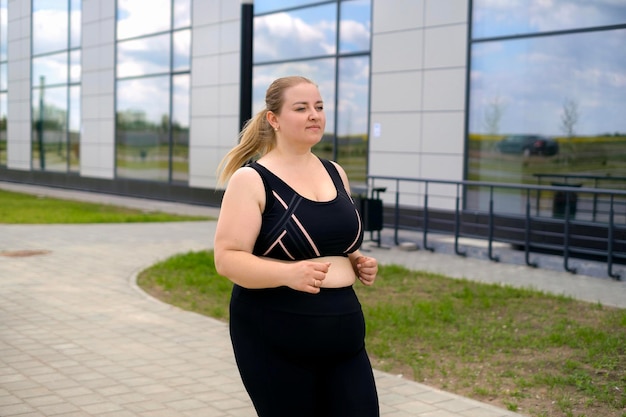 Mujer con sobrepeso graso en ropa deportiva en trote matutino