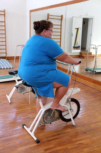 Mujer con sobrepeso haciendo ejercicio en bicicleta