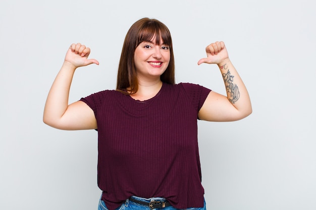 Mujer con sobrepeso que se siente orgullosa, arrogante y segura, que parece satisfecha y exitosa, apuntando a sí misma