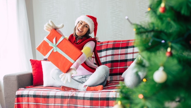 mujer en el sofá con caja de regalo