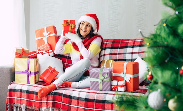 mujer en el sofá con caja de regalo