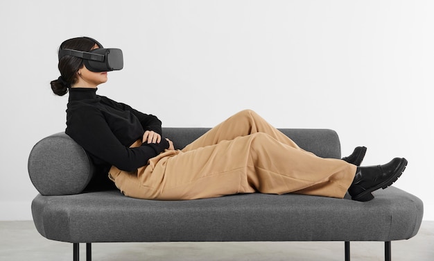 Mujer en el sofá con casco de realidad virtual