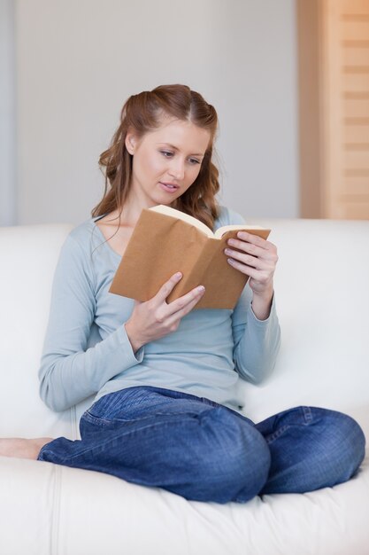 Mujer en el sofá se centró en su libro