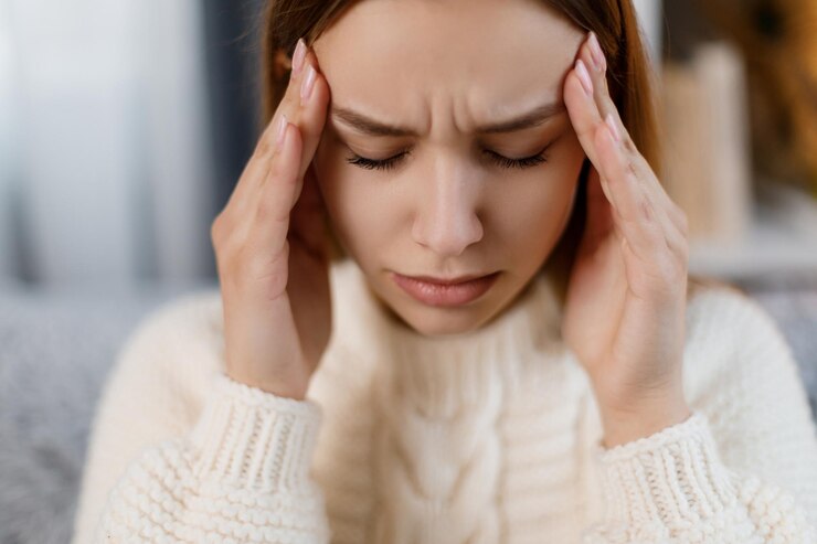 Mujer en el sofá que sufre de migraña