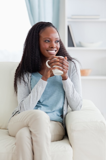 Mujer en el sofá con una taza