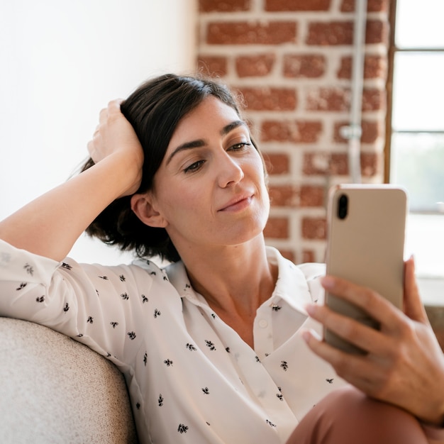 Mujer en el sofá con un teléfono inteligente