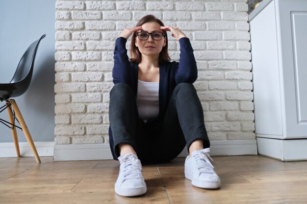 Foto mujer solitaria triste edad deprimida sentada en el piso