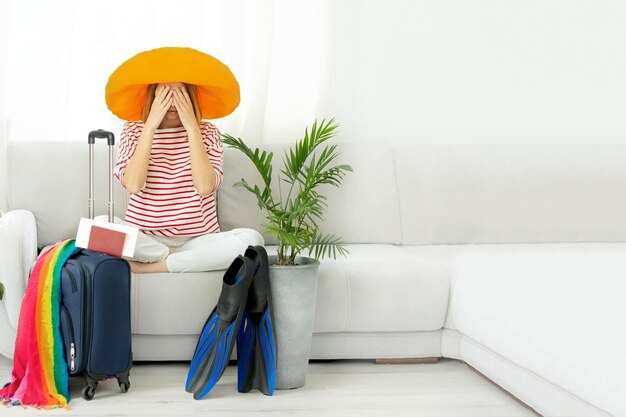 Foto la mujer con un sombrero amarillo se queda en casa y planea un viaje de vacaciones cerrando las fronteras de covid-19