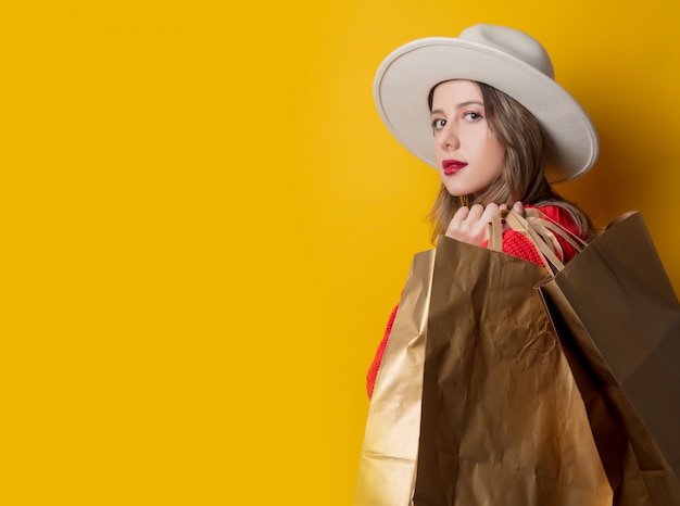 Mujer con sombrero y bolsas de compras