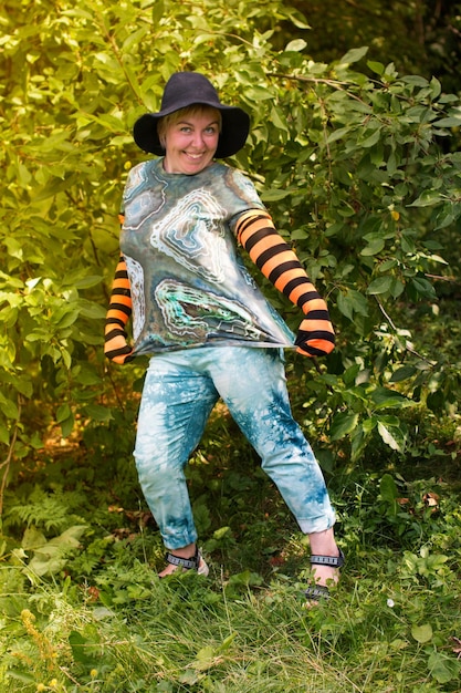 Una mujer con un sombrero de bruja para Halloween Un enano alegre en la naturaleza