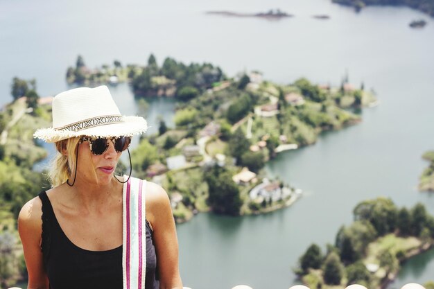 Mujer con sombrero contra el lago