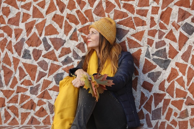 Foto mujer con sombrero contra la pared