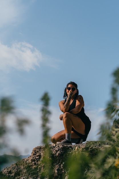 Mujer con sombrero disfrutando de la montaña, celebrando la vida.