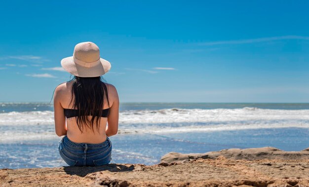 mujer con sombrero de espaldas al mar niña con sombrero mirando al mar una niña mirando el mar