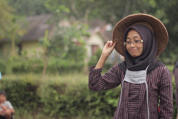 Una mujer con sombrero y gafas camina por el campo.