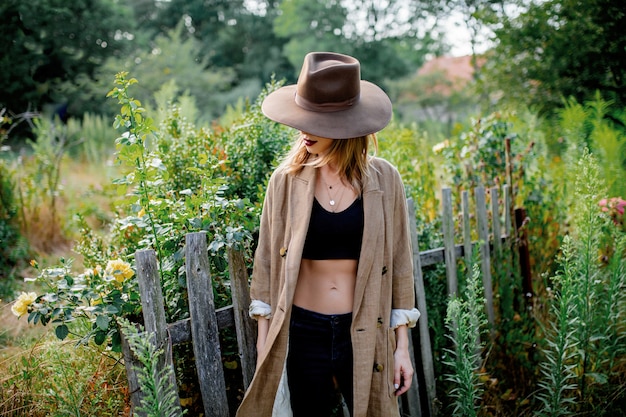 Mujer con sombrero en un jardín de campo de verano