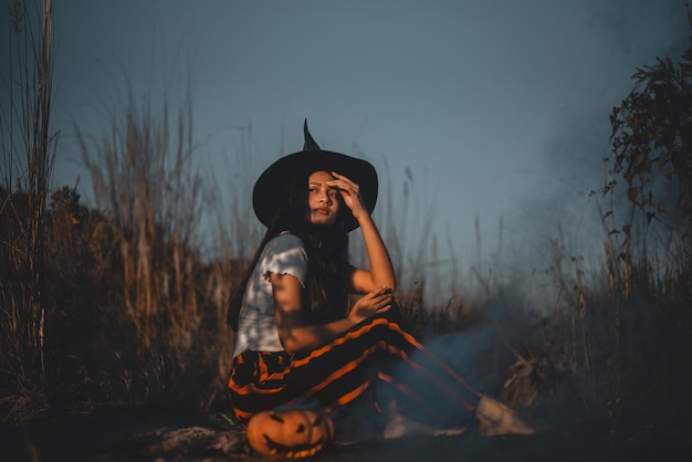 Mujer con sombrero mientras está de pie en tierra contra el cielo al atardecer