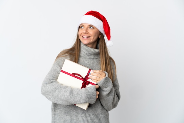 mujer con sombrero de navidad sosteniendo regalos