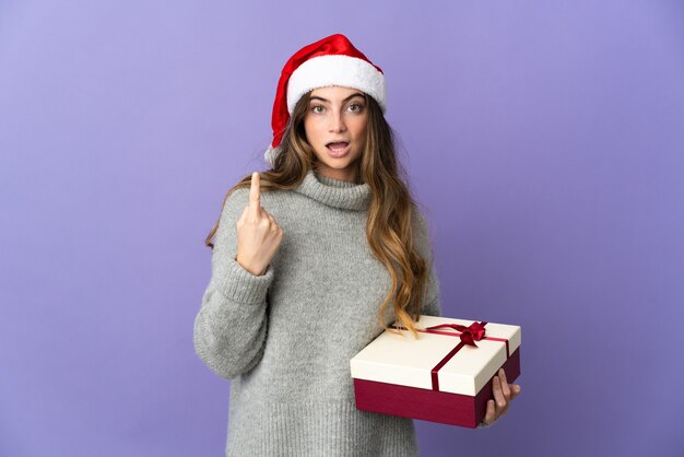 mujer con sombrero de navidad sosteniendo regalos