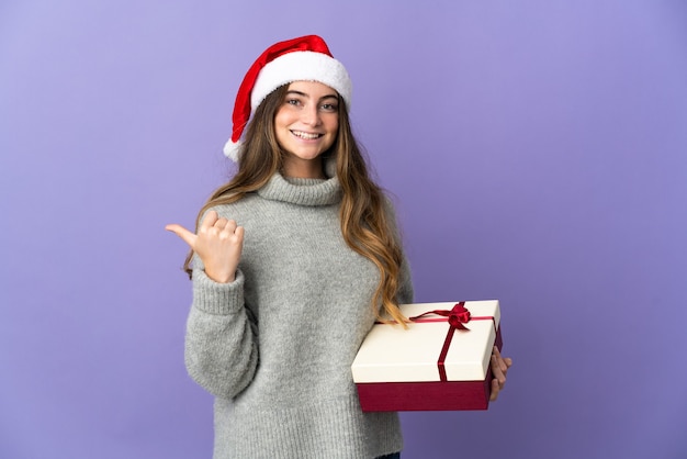 mujer con sombrero de navidad sosteniendo regalos