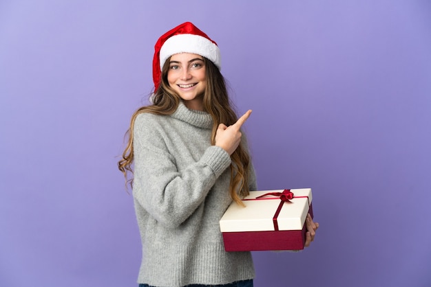 mujer con sombrero de navidad sosteniendo regalos