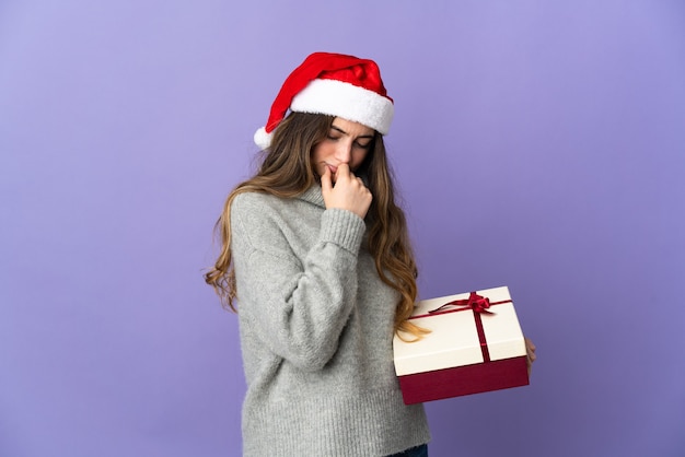 mujer con sombrero de navidad sosteniendo regalos