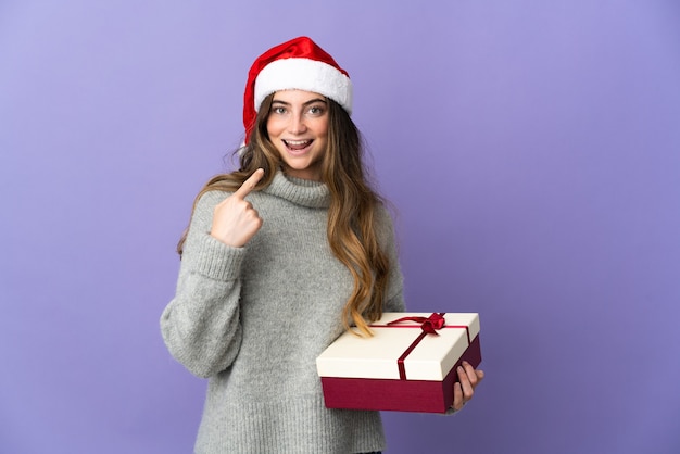 mujer con sombrero de navidad sosteniendo regalos