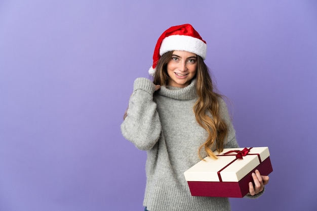 mujer con sombrero de navidad sosteniendo regalos