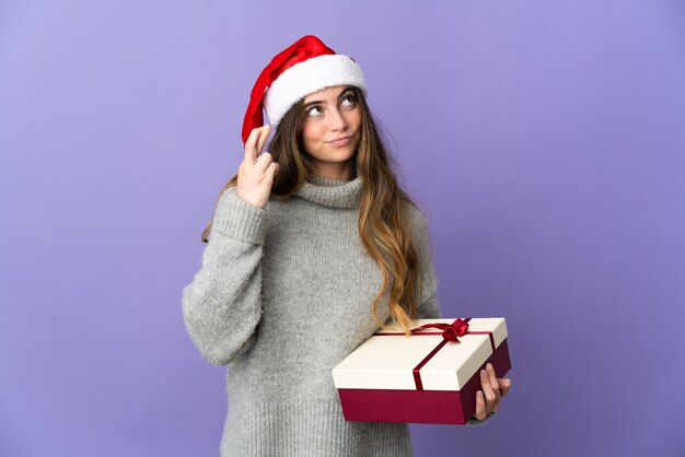 mujer con sombrero de navidad sosteniendo regalos