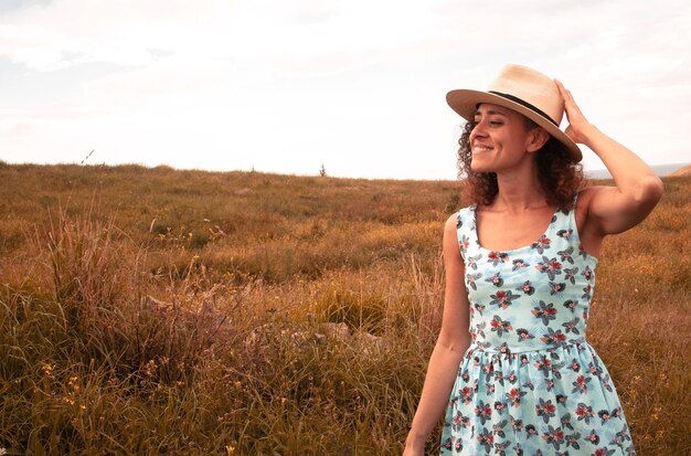 Foto mujer con sombrero de pie en el campo contra el cielo