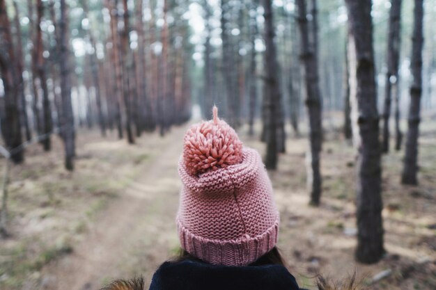 Foto mujer con sombrero de punto en el bosque