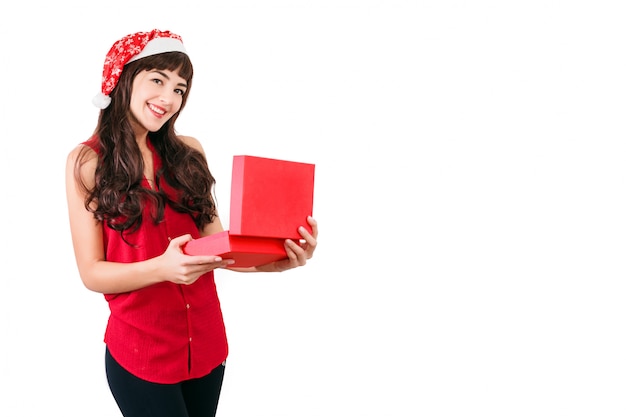 Mujer con sombrero de santa abriendo la caja de regalo de Navidad