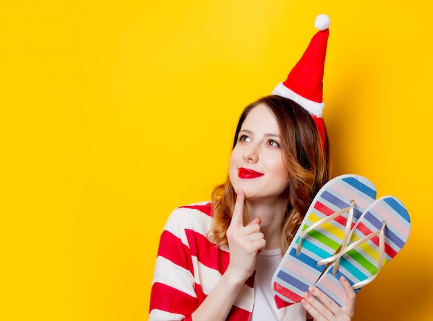 mujer en sombrero de santa claus con chanclas