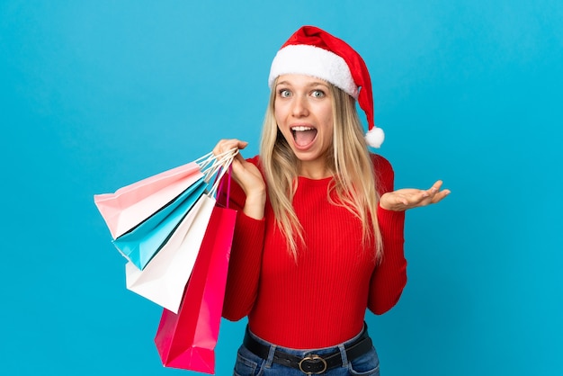 mujer con sombrero de santa, tenencia, bolsas de compras