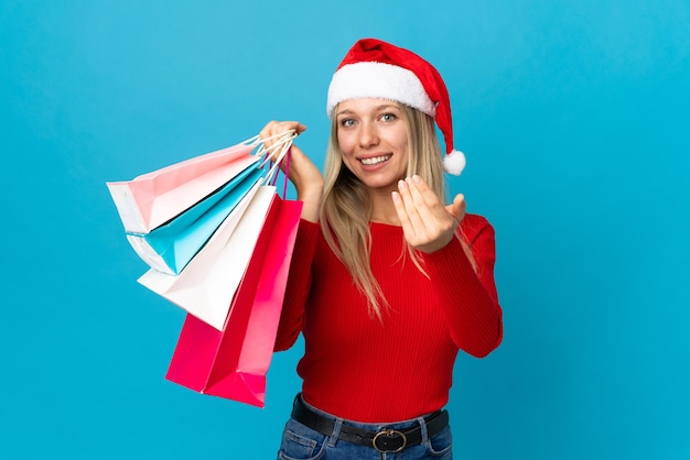 mujer con sombrero de santa, tenencia, bolsas de compras