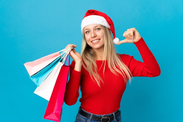 mujer con sombrero de santa, tenencia, bolsas de compras