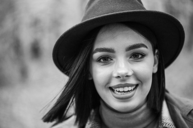 Una mujer con sombrero y suéter sonríe.