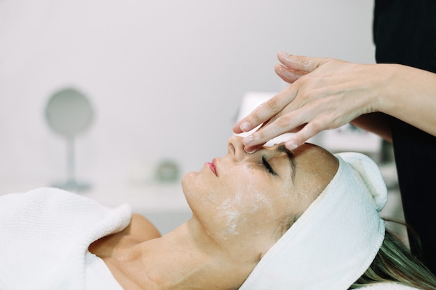 Mujer sometida a tratamiento con suero facial en salón de belleza.