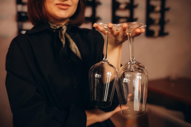 Foto mujer sommelier sosteniendo vasos vacíos