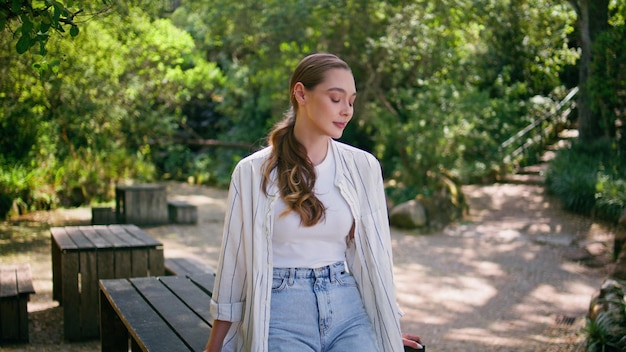 Mujer soñadora posando en el parque verde fin de semana soleado de primer plano chica disfrutando de la naturaleza sola